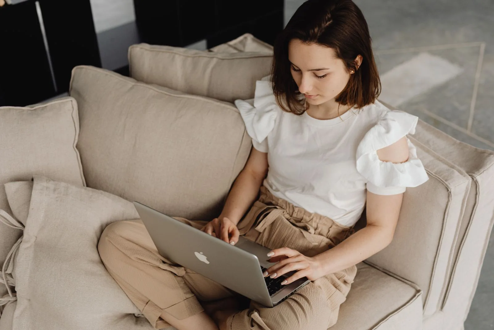 Selbstständige arbeitet mit dem Laptop auf dem Sofa