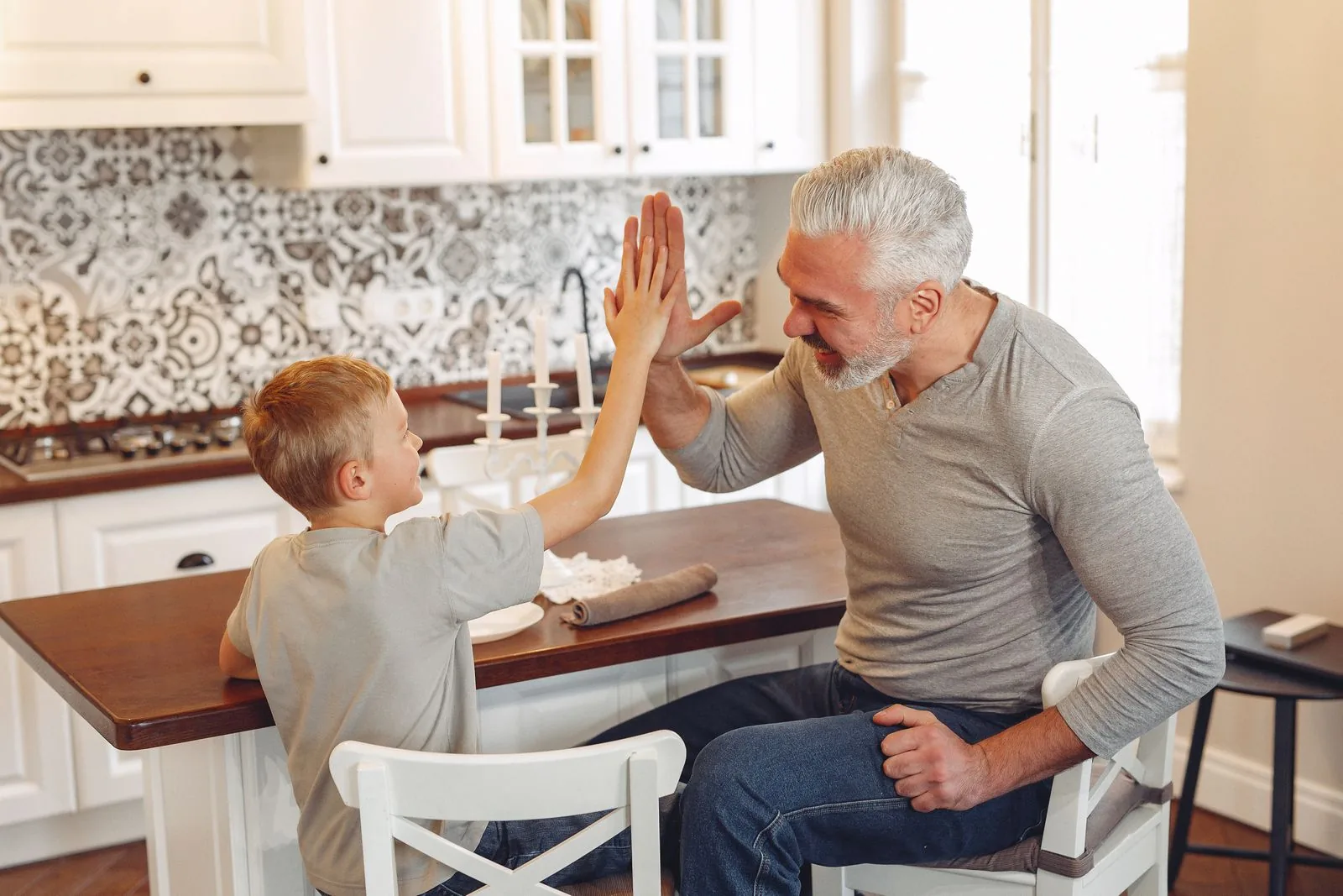Vater und Sohn geben sich in der Küche ein High five
